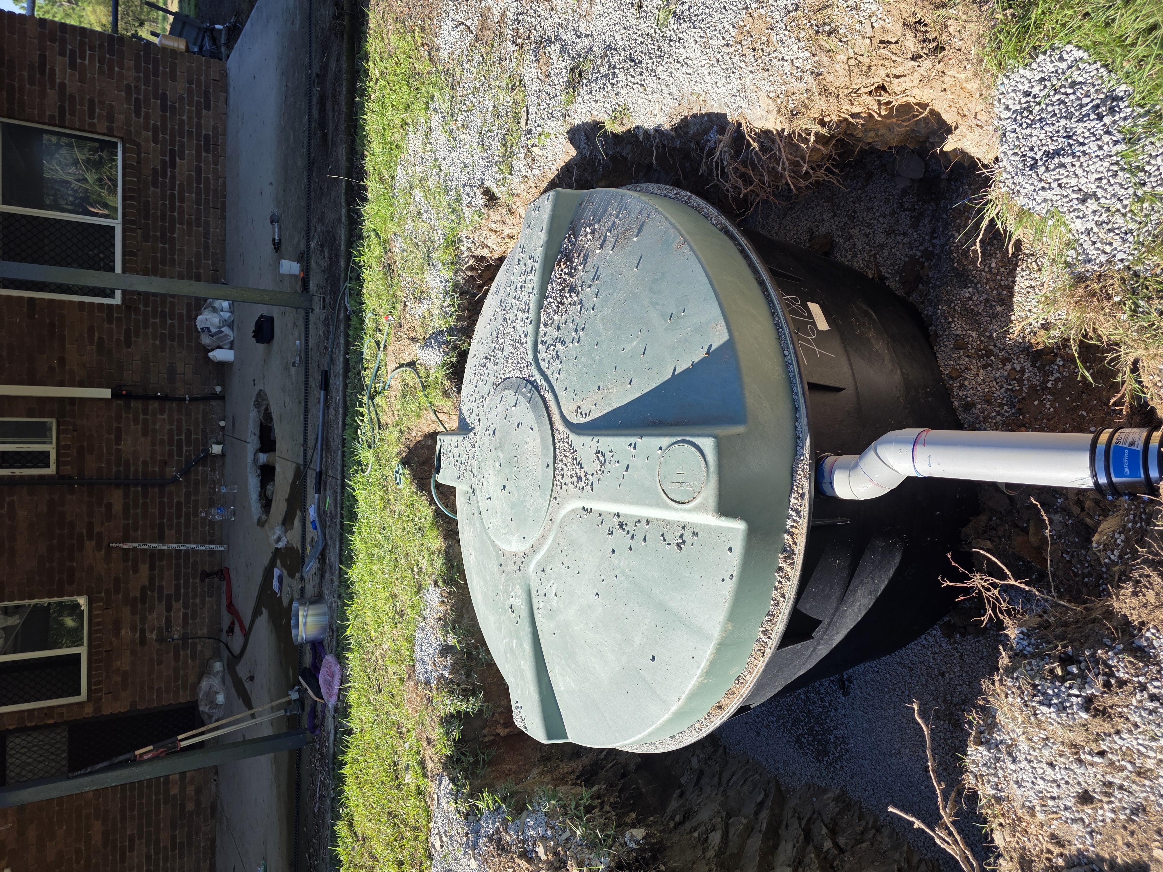 Septic tank installed and backfilled beside a home